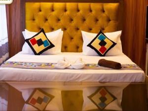 a bed with a yellow headboard and some pillows at Sisiliyana Stone Resort in Gonapola