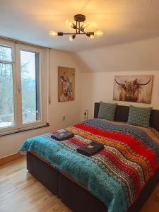 ein Schlafzimmer mit großem Bett und Fenster in der Unterkunft Wohlfühloase Schleiden Haus Talblick mit Whirlpool Kamin Aussicht 10 Personen in Schleiden