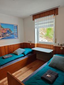 ein Zimmer mit zwei Betten und einem Fenster in der Unterkunft Wohlfühloase Schleiden Haus Talblick mit Whirlpool Kamin Aussicht 10 Personen in Schleiden