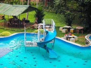 a blue water slide in a swimming pool at Sisiliyana Stone Resort in Gonapola