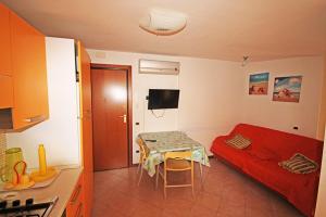 a small room with a red bed and a table at Soffio di mare in Alba Adriatica