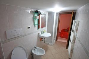 a bathroom with a white toilet and a sink at Soffio di mare in Alba Adriatica +22 photos