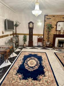 a living room with a blue rug and a grandfather clock at Luxury Lodge for Men in Cairo