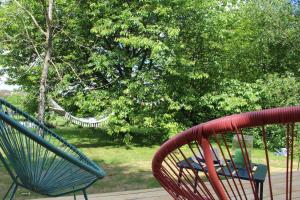 dwa krzesła i hamak w parku w obiekcie Cabane dans un jardin arboré w mieście LʼAbsie