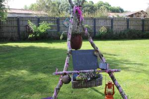 Stoisko z kwiatami z koszem i znakiem na nim w obiekcie Cabane dans un jardin arboré w mieście LʼAbsie