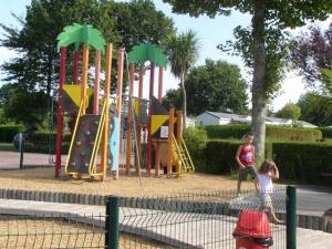 two children playing on a playground in a park at Camping 4 étoiles - Piscine - ccafgef in La Haye-du-Puits