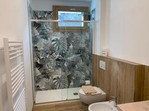 a bathroom with a shower with a toilet and a sink at IL COMO' DELLA CIVETTA - Nido del Picchio in Villa di Tirano +10 photos