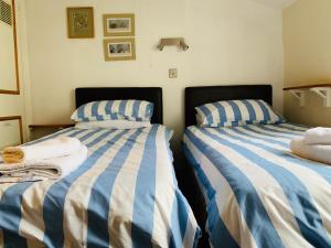 two beds sitting next to each other in a bedroom at Maypole Cottages No 10 Broad Street Padstow in Padstow
