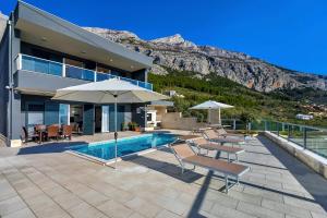 a house with a swimming pool with a mountain at Villa Infinite in Makarska