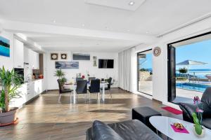 a living room with a table and chairs and a dining room at Villa Infinite in Makarska