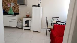 a kitchen with a white refrigerator and a table with chairs at Apartamento Arcoverde 02 in Arcoverde