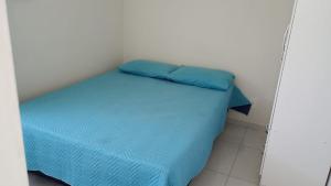 a small room with a bed with blue sheets at Apartamento Arcoverde 02 in Arcoverde