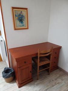 a wooden desk with a chair next to a wall at E lu chantauziau in La Monnerie-le Montel