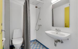 Un baño con lavabo, inodoro y espejo. en Fanø Bad, Værelse 26, en Fanø
