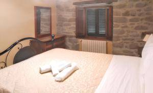 a bedroom with a bed with two towels on it at Cozy House in Caprese Michelangelo + Pool in Arezzo