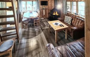 a living room with a couch and a table and a fireplace at Gorgeous Home In Idre With Kitchen in Foskros