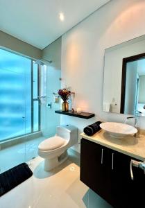 a bathroom with a toilet and a sink and a mirror at Emmaus in Cartagena de Indias