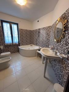 a bathroom with a tub and a toilet and a sink at B&B Il Papavero in Tuscania