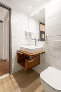 a white bathroom with a sink and a toilet at Captain's Seafront Apartments in Nydri +119 photos