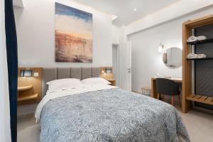 a bedroom with a large bed and a desk at Captain's Seafront Apartments in Nydri