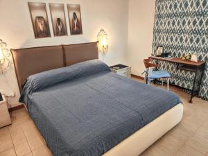 a bedroom with a bed with a blue blanket at Elegant Villa with Private Pool in Alcamo Marina – Sea View in Alcamo Marina +85 photos