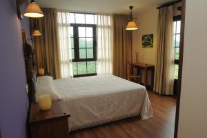 a bedroom with a white bed and a window at El Quesar de Gamoneo in Gamonedo de Cangas +68 photos