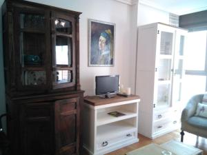 ein Wohnzimmer mit einer Kommode, einem Fernseher und einem Schrank in der Unterkunft Miguelete in Selaya