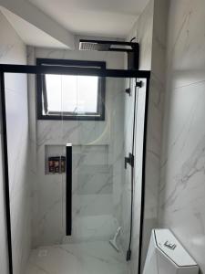 a shower with a glass door in a bathroom at Suíte privada Mariscal in Bombinhas