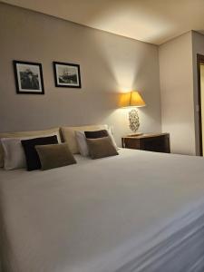 a bedroom with a large white bed and a lamp at Casa Garay Hotel 658 in Asuncion