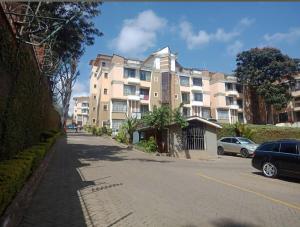 a large apartment building on the side of a street at Riverside Spacious Haven in Nairobi