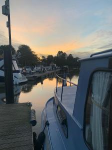 Ein Boot liegt bei Sonnenuntergang in einem Yachthafen in der Unterkunft Stunning Classic Dutch Barge near Henley & Marlow in Bourne End