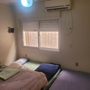 ロザリオ・ド・スルにあるMi casa es su casa!のベッド2台と窓のある寝室