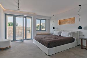 een slaapkamer met een bed en glazen schuifdeuren bij Empire Luxury Villas in Santa Maria +90 foto's
