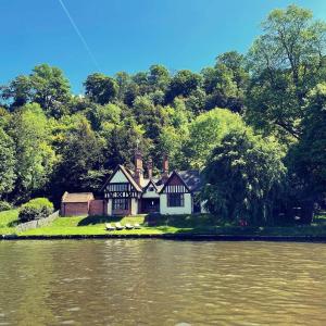 ein Haus auf einer Insel mitten in einem Fluss in der Unterkunft Stunning Classic Dutch Barge near Henley & Marlow in Bourne End