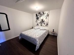a bedroom with a bed and a painting on the wall at Le Contrasté in Clermont-Ferrand
