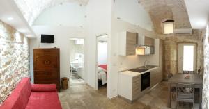 a living room with a red couch and a kitchen at Lilla B&B Luxury Apartments in Molfetta