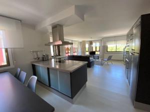 a kitchen and living room with a table and a stove at Housingcoruña Apartamento Playa Miño 03 in Miño