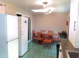 a kitchen with a table and chairs and a refrigerator at YPCC Accommodations in Bradford