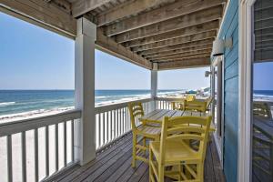 un portico con sedie gialle e un tavolo sulla spiaggia di BeachFront 18Bed Pool EasyBreezy a Gulf Shores