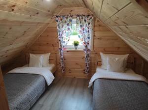 two beds in a room with a window at Domek całoroczny 6 osobowy in Wroceń