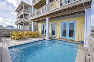 a swimming pool with chairs and a house at BeachFront 8Bedrooms Lemonshello in Gulf Shores