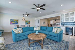 un salon avec un canapé bleu et une table dans l'établissement BeachFront 5Bed EasyBreezy East, à Gulf Shores