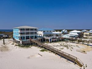 un grand bâtiment bleu sur la plage à côté du sable dans l'établissement BeachFront 5Bed EasyBreezy East, à Gulf Shores