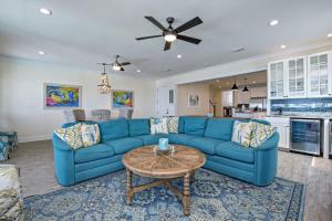 un salon avec un canapé bleu et une table dans l'établissement BeachFront 9Bed EasyBreezy East, à Gulf Shores