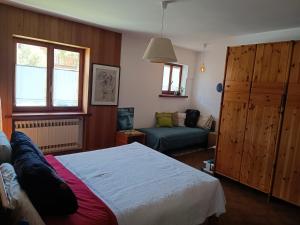 une chambre avec un lit et un canapé dans l'établissement Bilocale relax in Cesana, à Césane