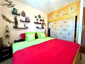 Un dormitorio con una cama grande con una manta roja. en Welooveyou Parrots, en Costa Calma