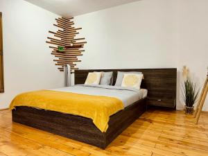 a bedroom with a bed with a yellow blanket on it at Old Town by HYCO in Sighişoara