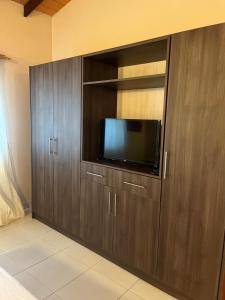 a room with wooden cabinets with a flat screen tv at Mandala Apartments 2 ambientes in Luque