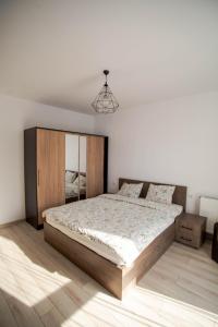 a bedroom with a large bed with a wooden headboard at Oasis Retreat Rasnov in Râşnov