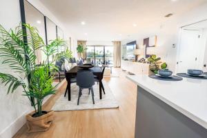 a kitchen and dining room with a table and plants at The Sunset Cove in Wesley Chapel